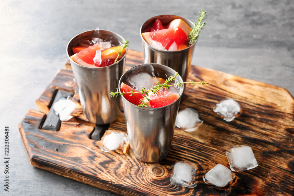 Glasses of refreshing grapefruit lemonade on wooden board