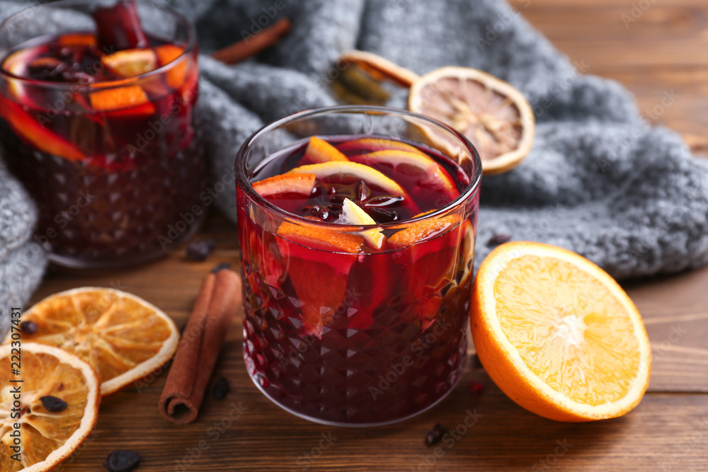 Glasses of delicious mulled wine on wooden table