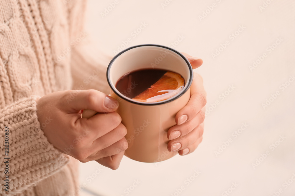 女人拿着金属杯美味的热葡萄酒，特写