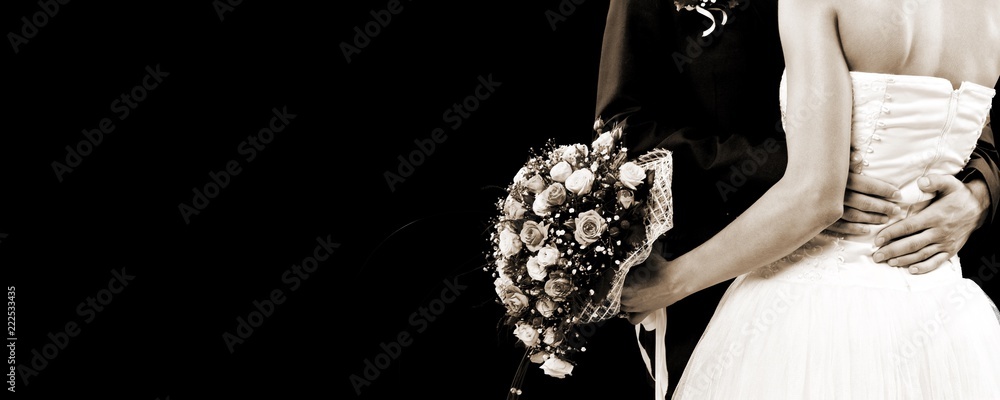 Bride and groom hugging on light background