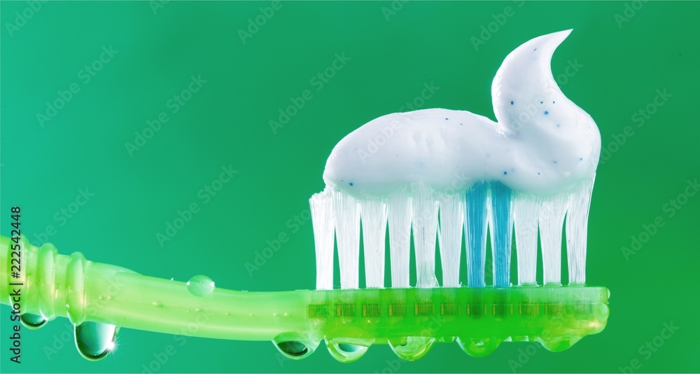 Toothpaste on a toothbrush on background