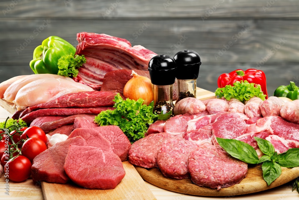 Fresh raw meat background with vegetables on wooden desk