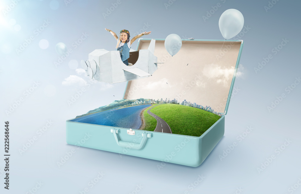 Little asian girl enjoy with fantasy cardboard plane fly and floating in an open retro vintage suitc