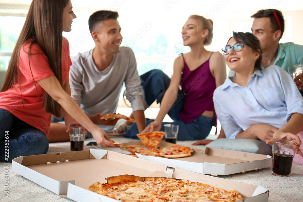 Young people having fun at party with delicious pizza indoors