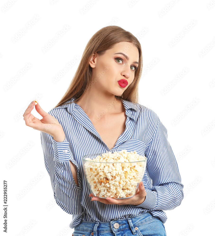 Beautiful young woman with bowl of popcorn on white background