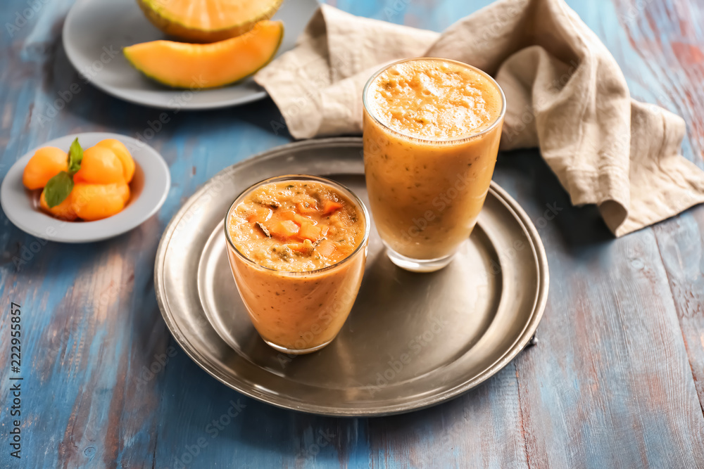 Glasses of tasty melon smoothie on wooden table