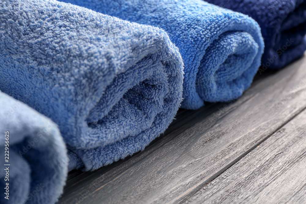 Clean soft towels on wooden table, closeup