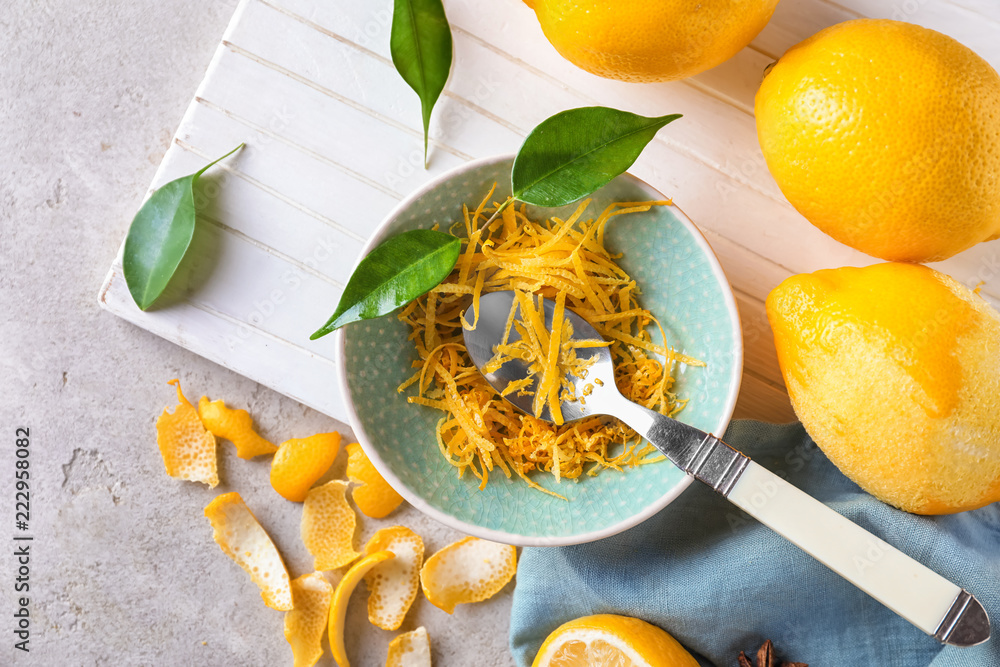 Ripe lemons with zest on wooden board