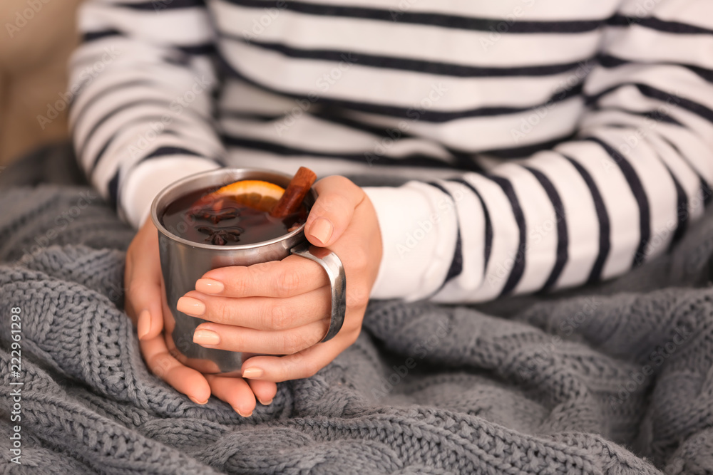 Woman holding metal cup of delicious mulled wine, closeup