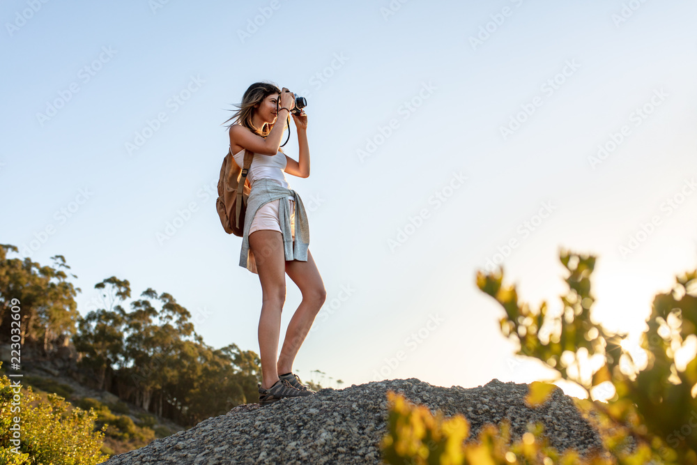 徒步旅行者在山上用相机拍照