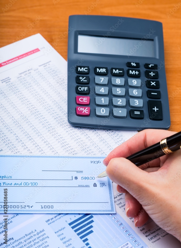 Close-up of a Businesswoman Signing a Check on Desk