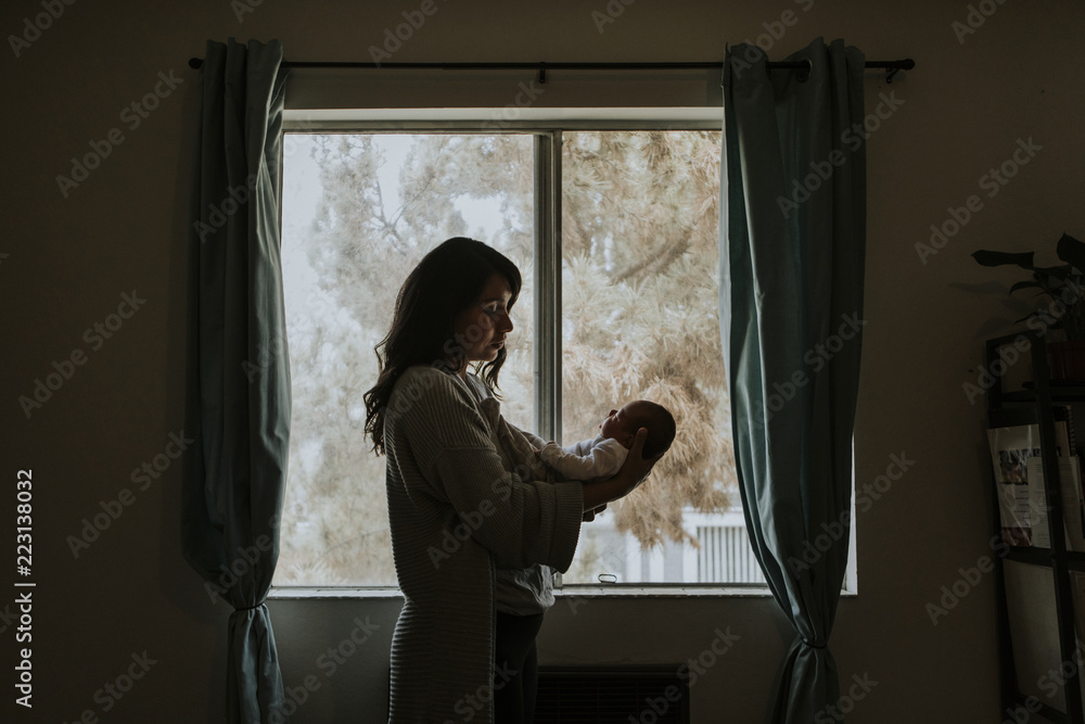 Mother holding her baby indoors