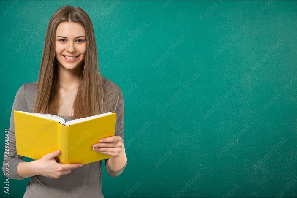 Young female student on blurred library background