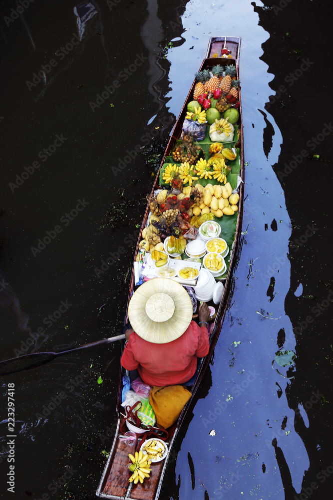 泰国Damnoen Saduak浮动市场，一名妇女在船上交易水果和食物