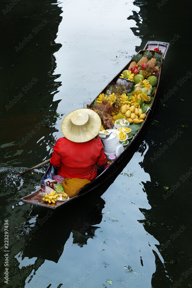 泰国Damnoen Saduak浮动市场，一名妇女在船上交易水果和食物