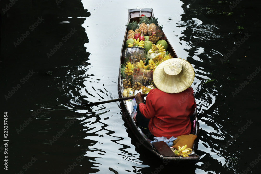 泰国Damnoen Saduak浮动市场，一名妇女在船上交易水果和食物