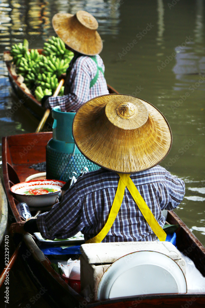 泰国Damnoen Saduak浮动市场，一名妇女在船上交易水果和食物