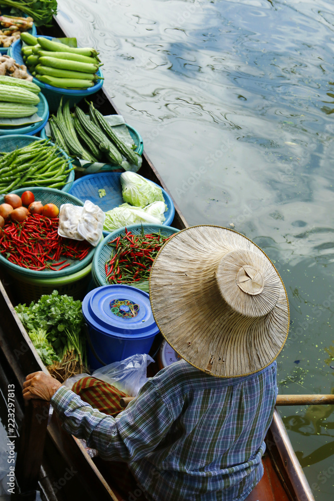 泰国Damnoen Saduak浮动市场，一名妇女在船上交易水果和食物