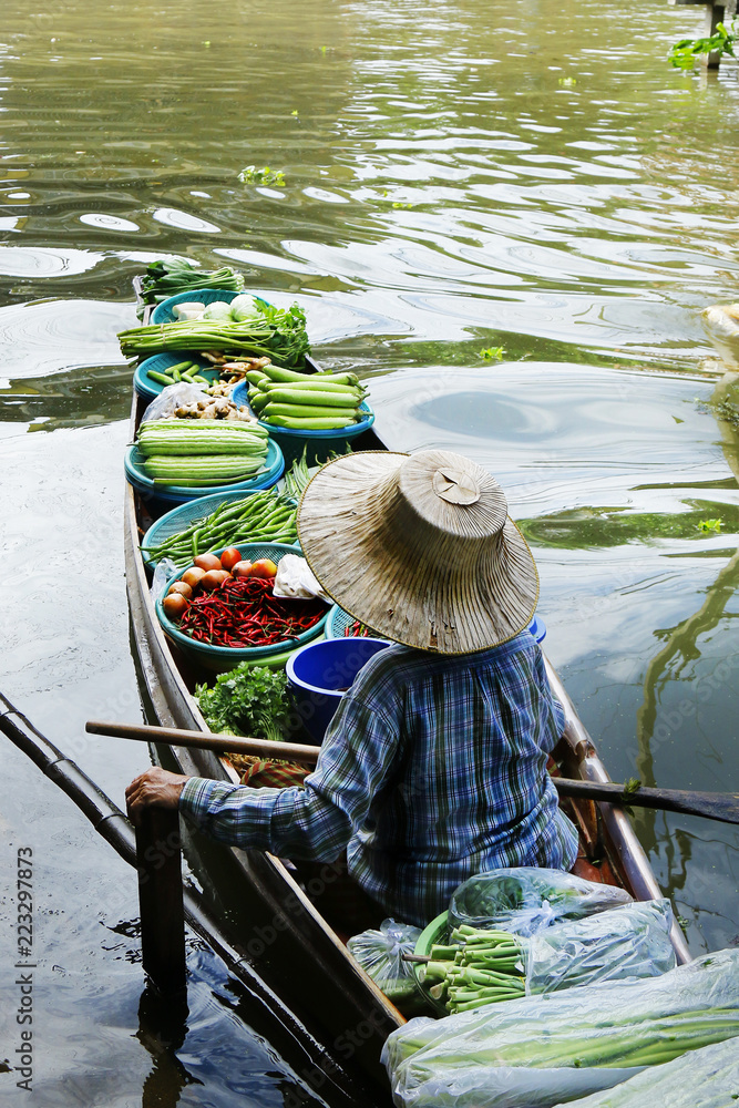 泰国Damnoen Saduak浮动市场，一名妇女在船上交易水果和食物