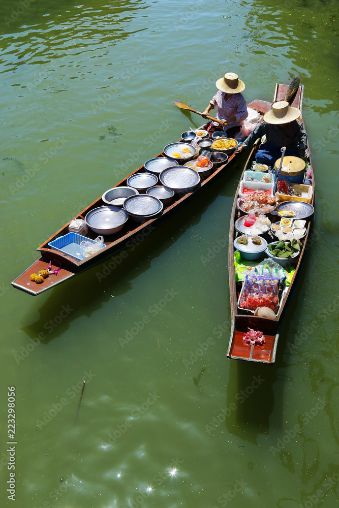 泰国Damnoen Saduak浮动市场，一名妇女在船上交易水果和食物