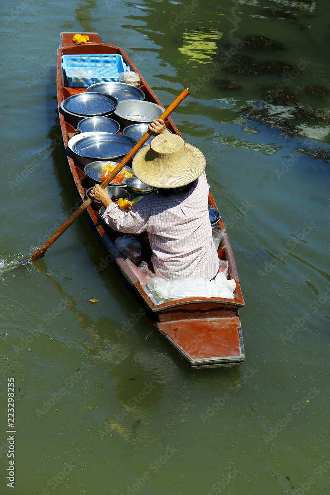 泰国Damnoen Saduak浮动市场，一名妇女在船上交易水果和食物