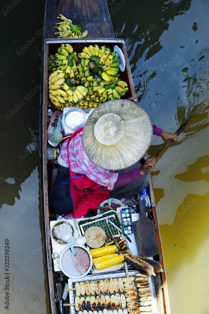 泰国Damnoen Saduak浮动市场，一名妇女在船上交易水果和食物