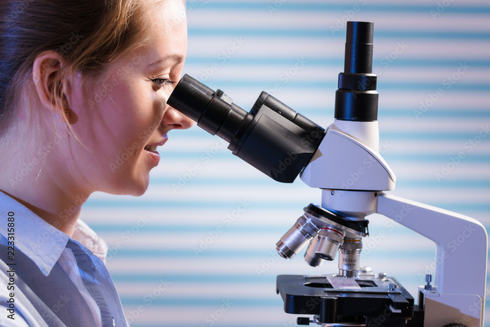 Young scientist using a microscope in a laboratory