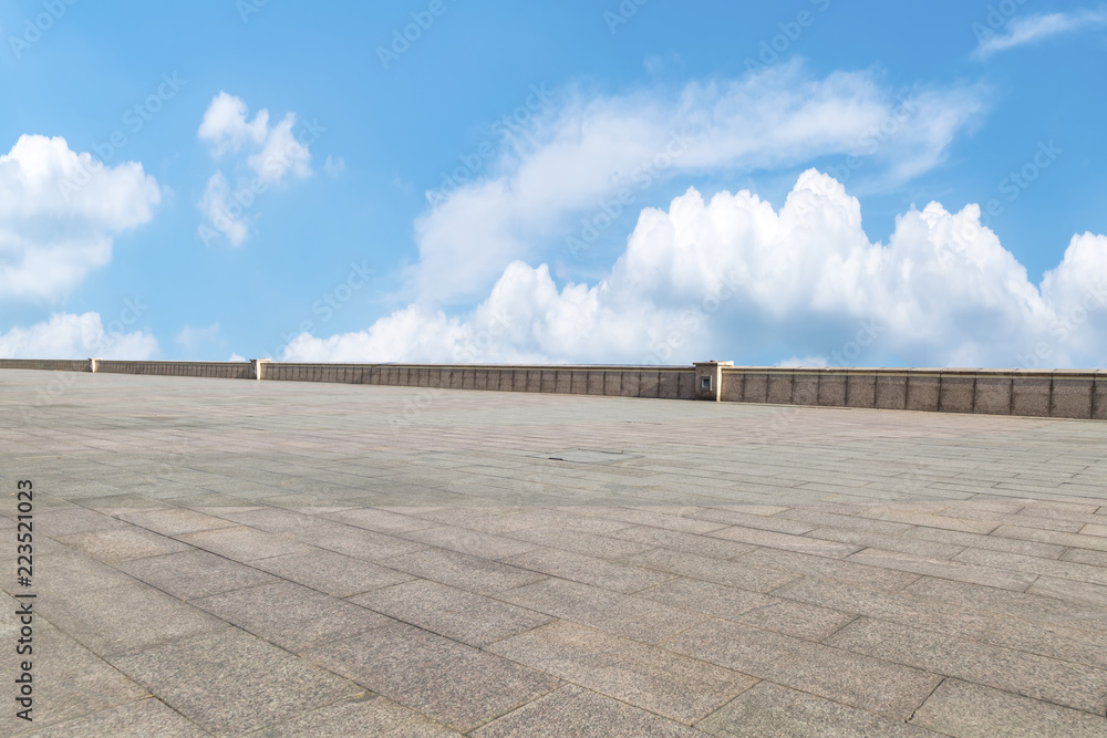 Empty stone floor under blue sky and white clouds