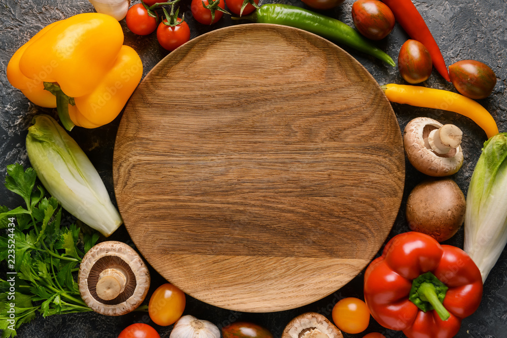 Flat lay composition with fresh vegetables and tray on dark background