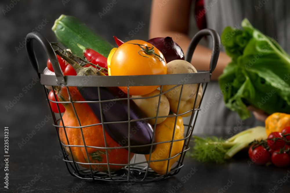 Metal basket with fresh vegetables on table