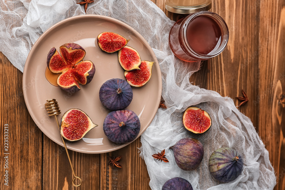 Plate with fresh ripe figs on wooden table