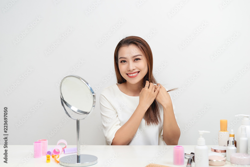 Portrait of brunette woman looking at her face in mirror