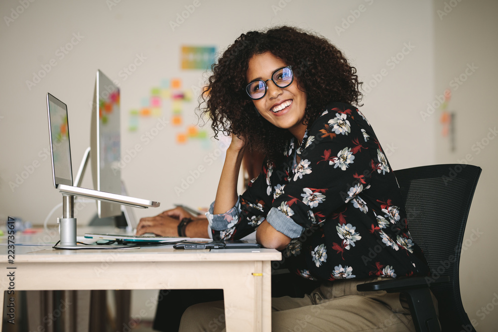 Woman entrepreneur sitting at her work station in office