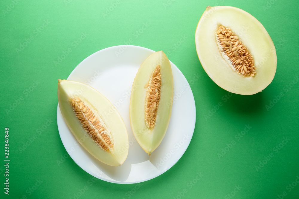 Melon sliced on bright green background. Minimal fruit concept.