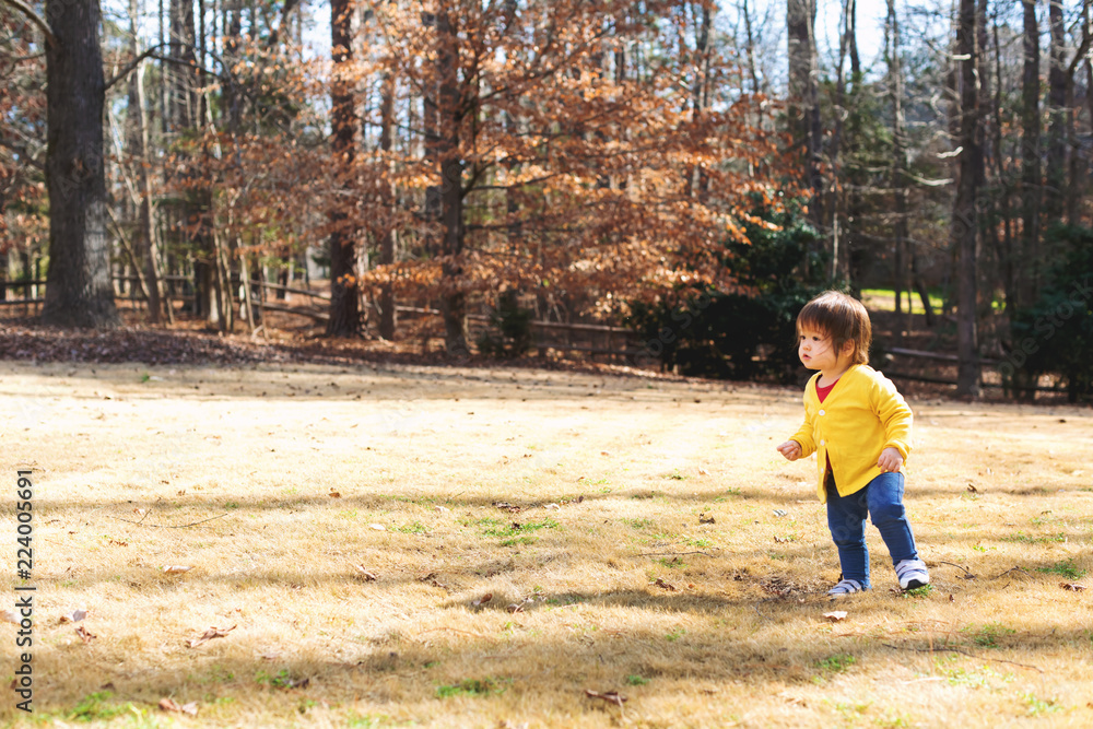 Happy asian toddler boy playing outside on a sunny day