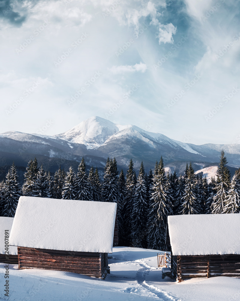 Fantastic winter landscape with wooden house in snowy mountains. Christmas holiday concept. Carpathi