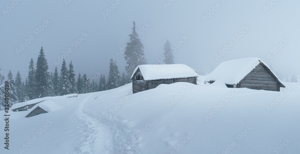 Fantastic winter landscape with wooden house in snowy mountains. Christmas holiday concept. Carpathi