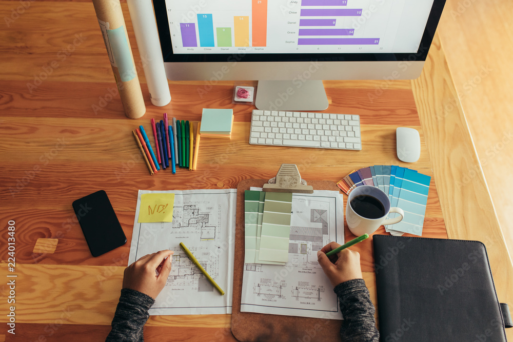 Architect working over new blueprints at her desk