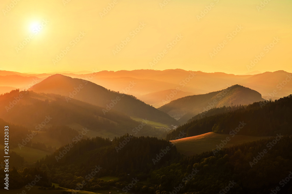 群山周围美丽的日落景色。天空中的阳光