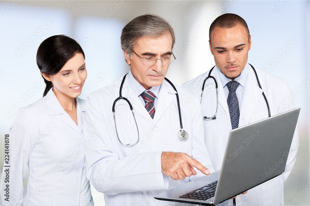 Male doctors with stethoscope using computer on