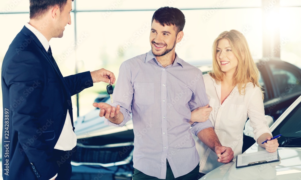 Happy family with car dealer in auto