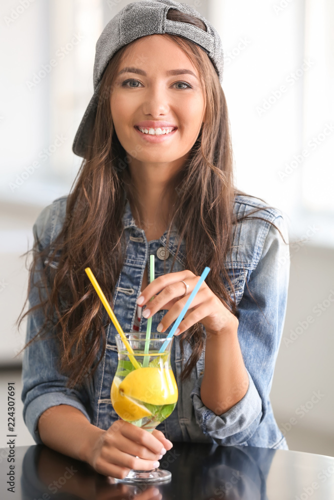 Young woman drinking fresh lemonade at home