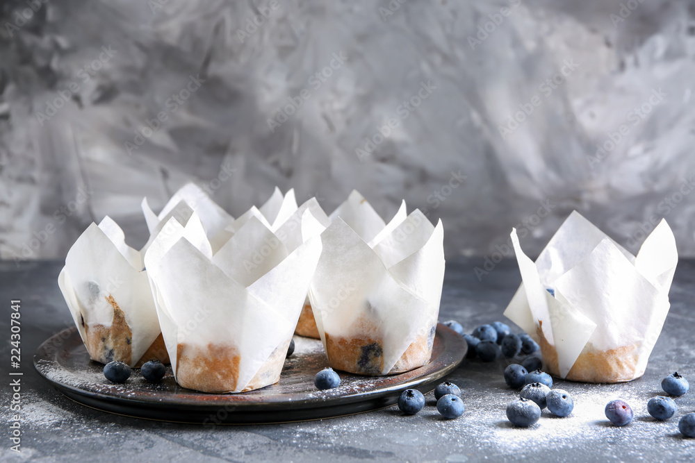 Tray with tasty blueberry muffins on grey table