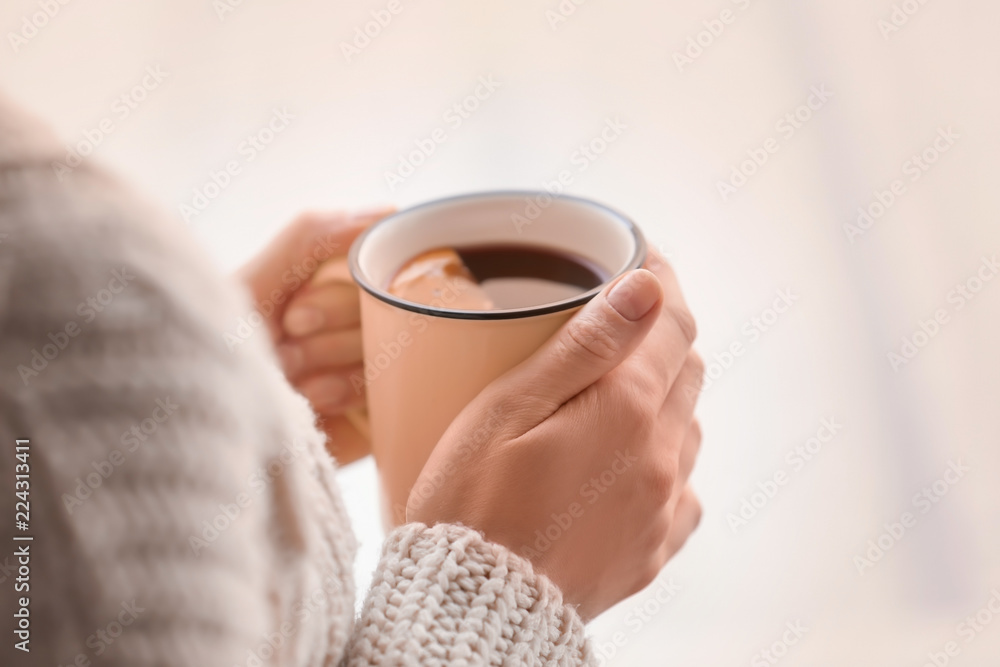 女人拿着一杯美味的热葡萄酒，特写镜头