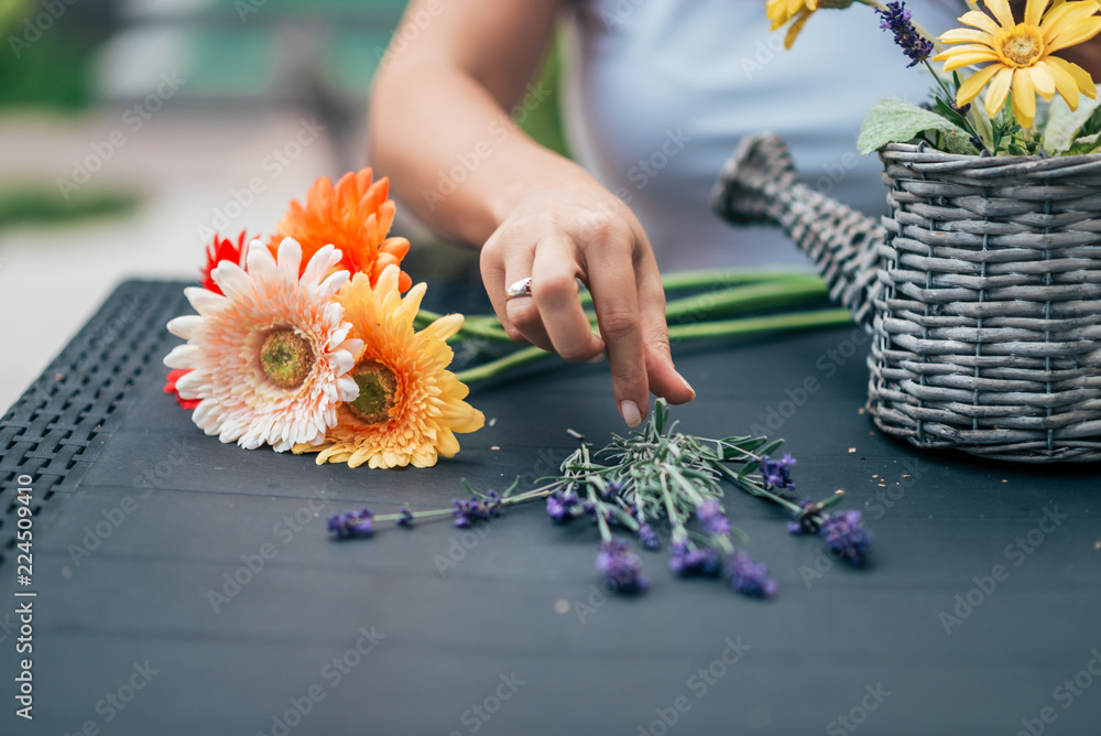 Arranging flower basket outdoors.