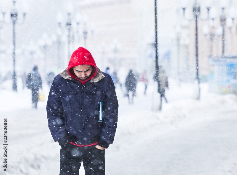 大雪下的城市街道上的男人