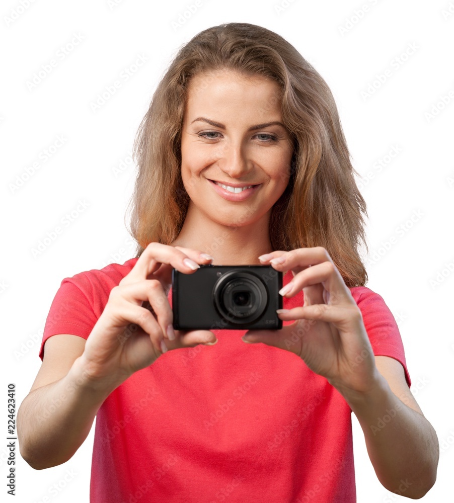 Pretty young woman holding camera isolated on white background