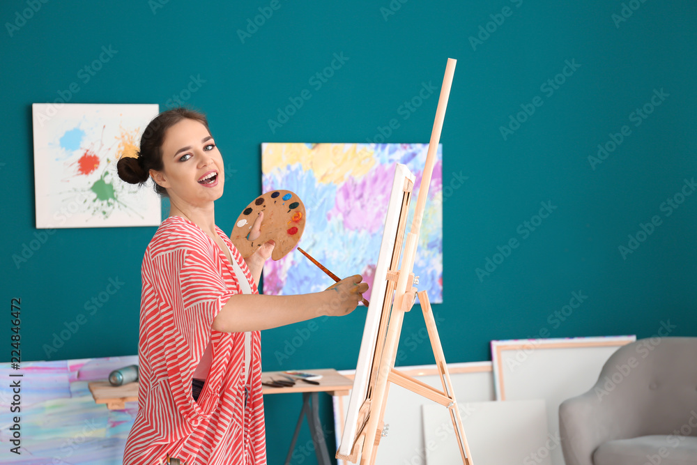 Female artist painting picture in workshop