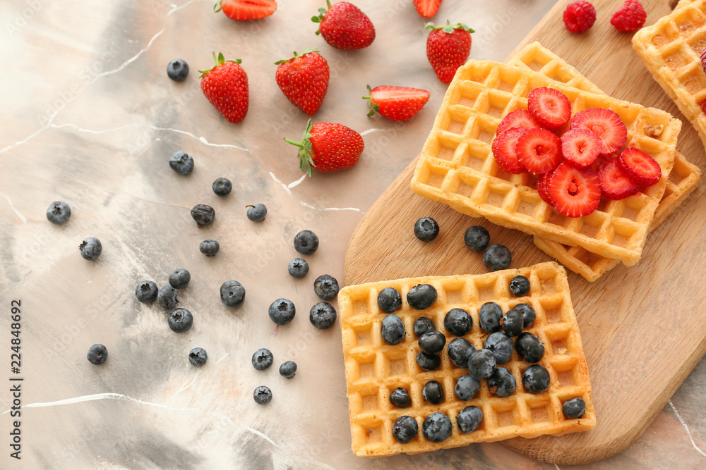 Delicious waffles with berries on table, top view