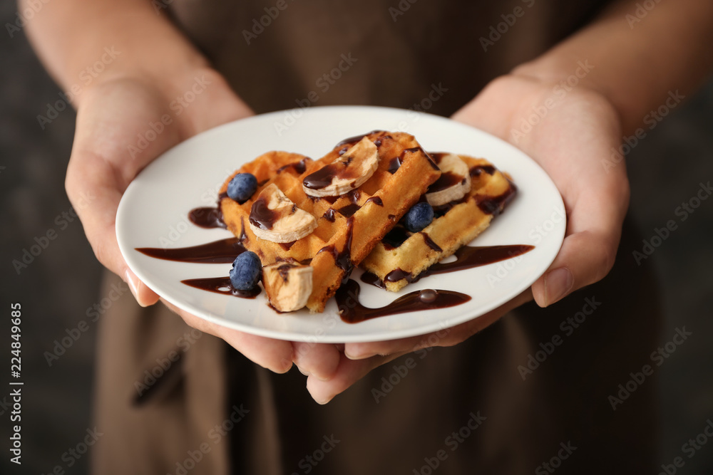 拿着美味华夫饼和浆果的盘子的女人，特写